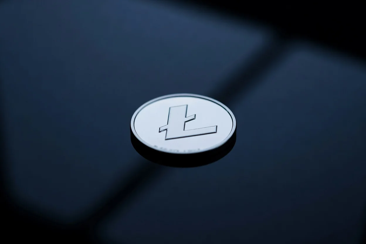 Moneta argentata con il simbolo di Litecoin su superficie riflettente scura